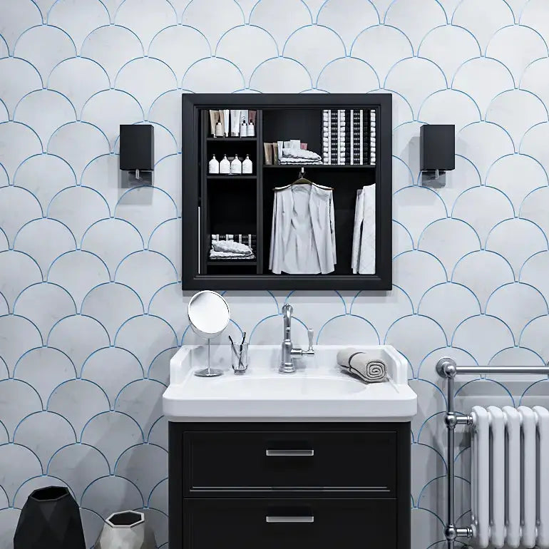 Ebisu marble mosaic tile installed on a modern bathroom wall featuring a repeating fish-scale pattern with delicate blue lines, accented by a dark vanity, white sink basin, and matching black framed wall cabinet.