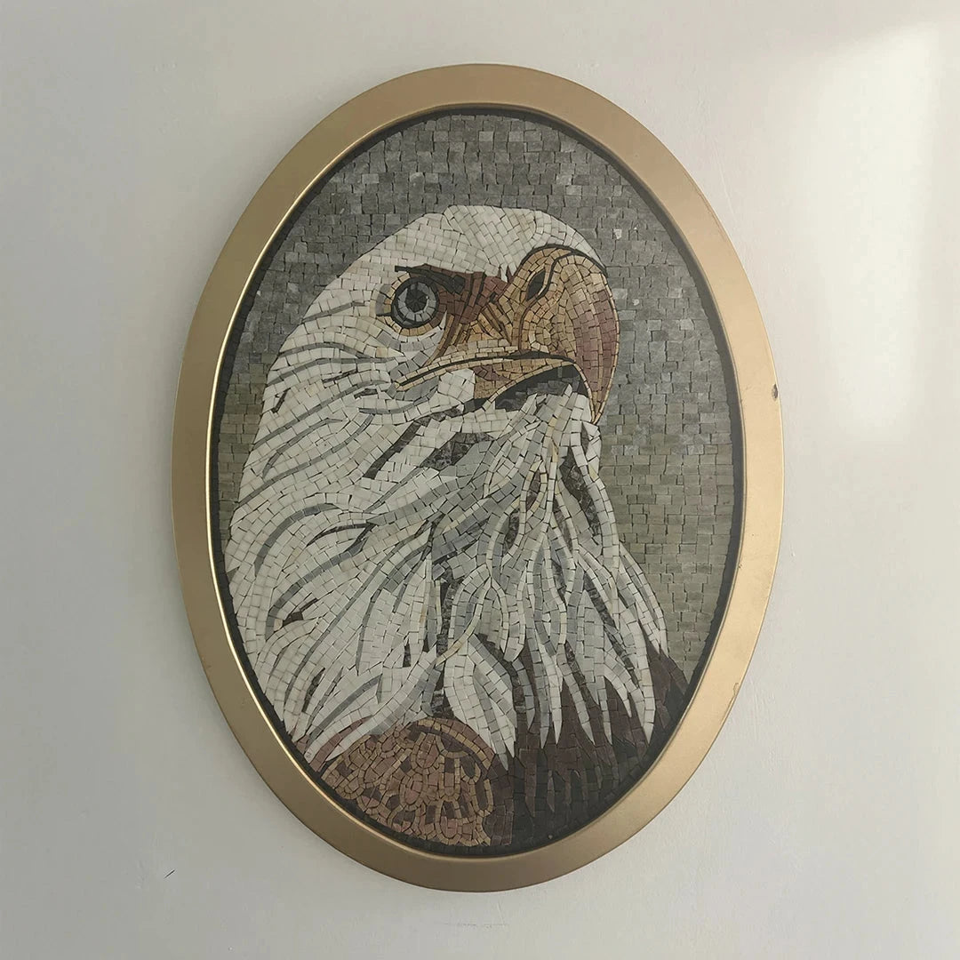 Mosaic artwork of an eagle head in a gold frame on a white wall