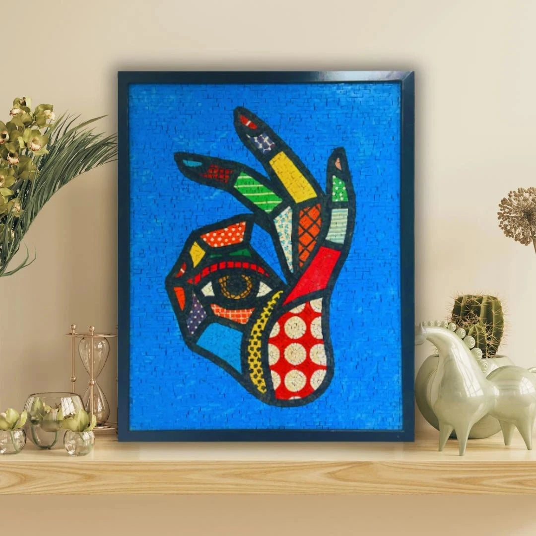 Framed colorful abstract art piece on a shelf with decorative items.