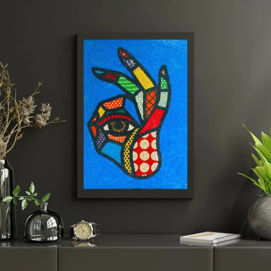 Framed abstract artwork on a dark wall with decorative items below.