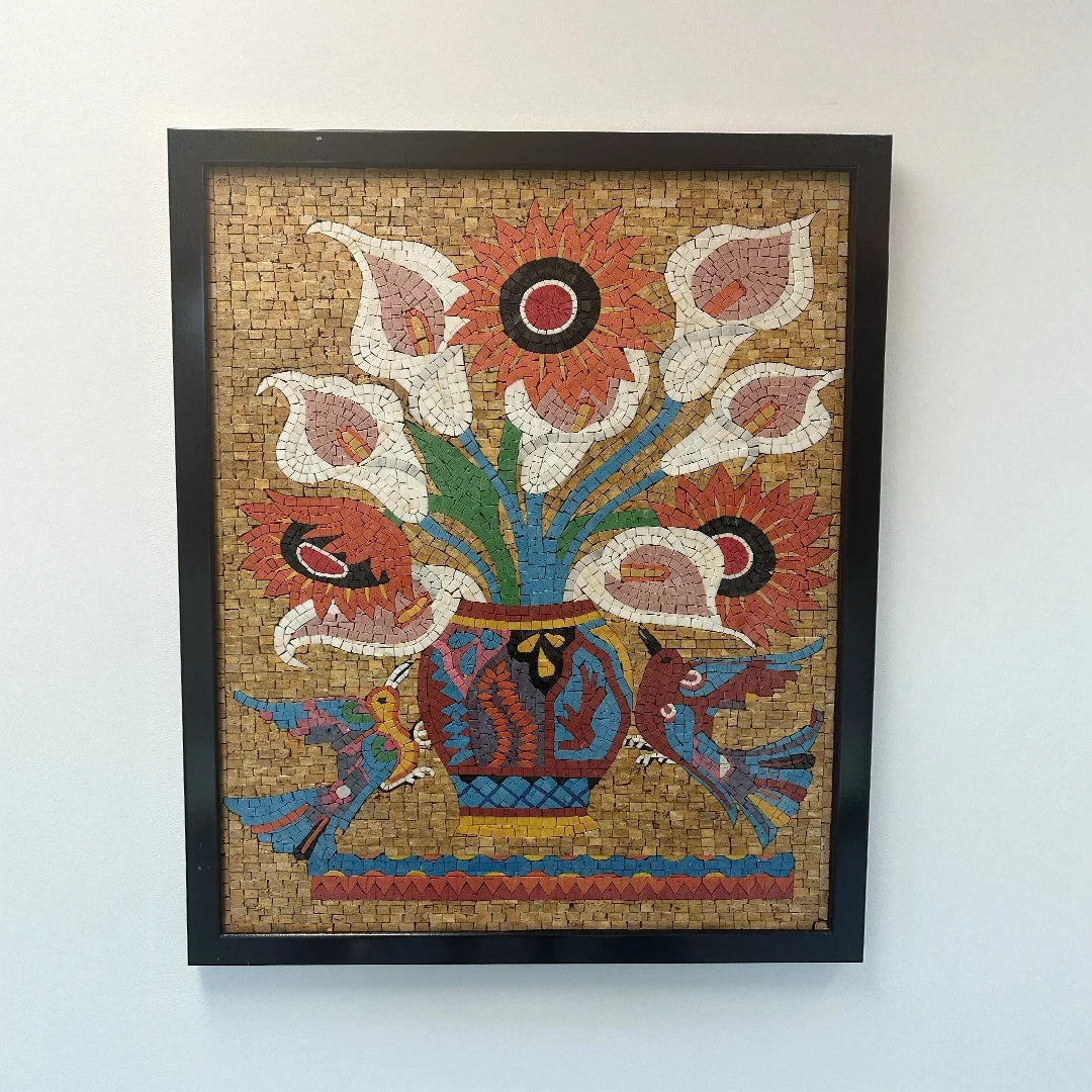 Framed mosaic artwork of flowers and birds on a white wall