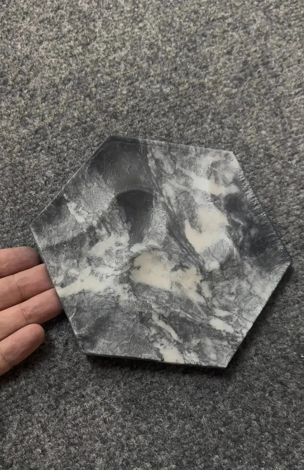 Hexagonal stone with a central hole on a gray surface