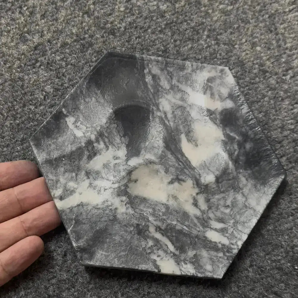 Hexagonal stone with a central hole on a gray surface