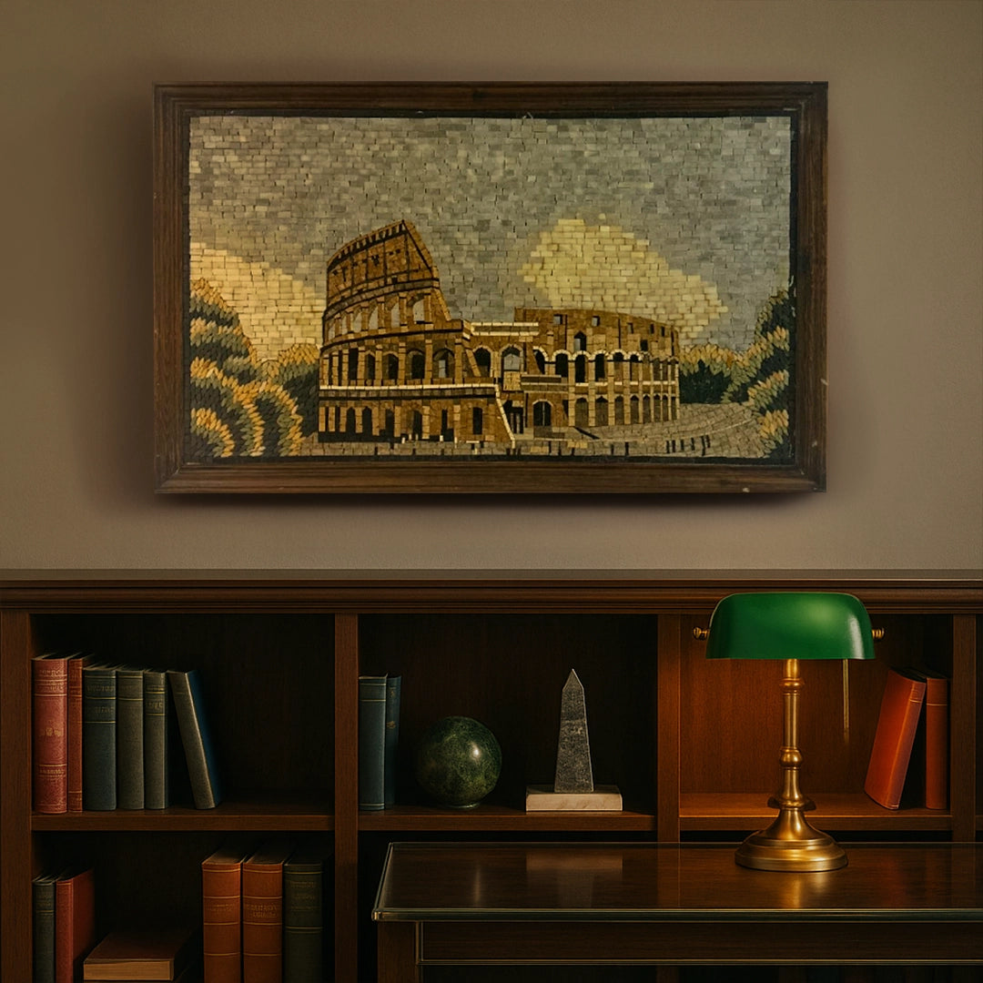 Framed mosaic of the Colosseum above a bookshelf with a lamp.