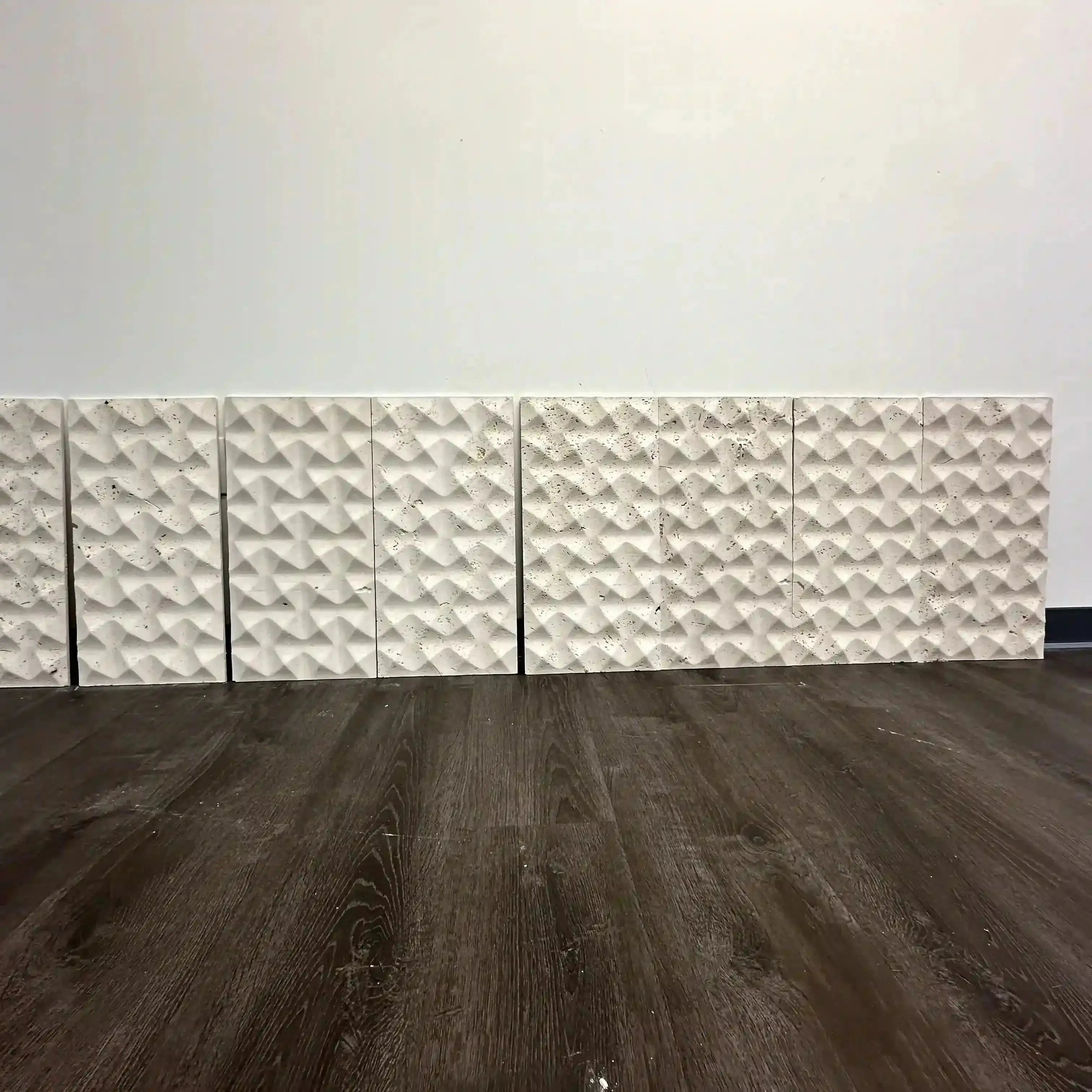 Wall with decorative 3D textured panels on a wooden floor.