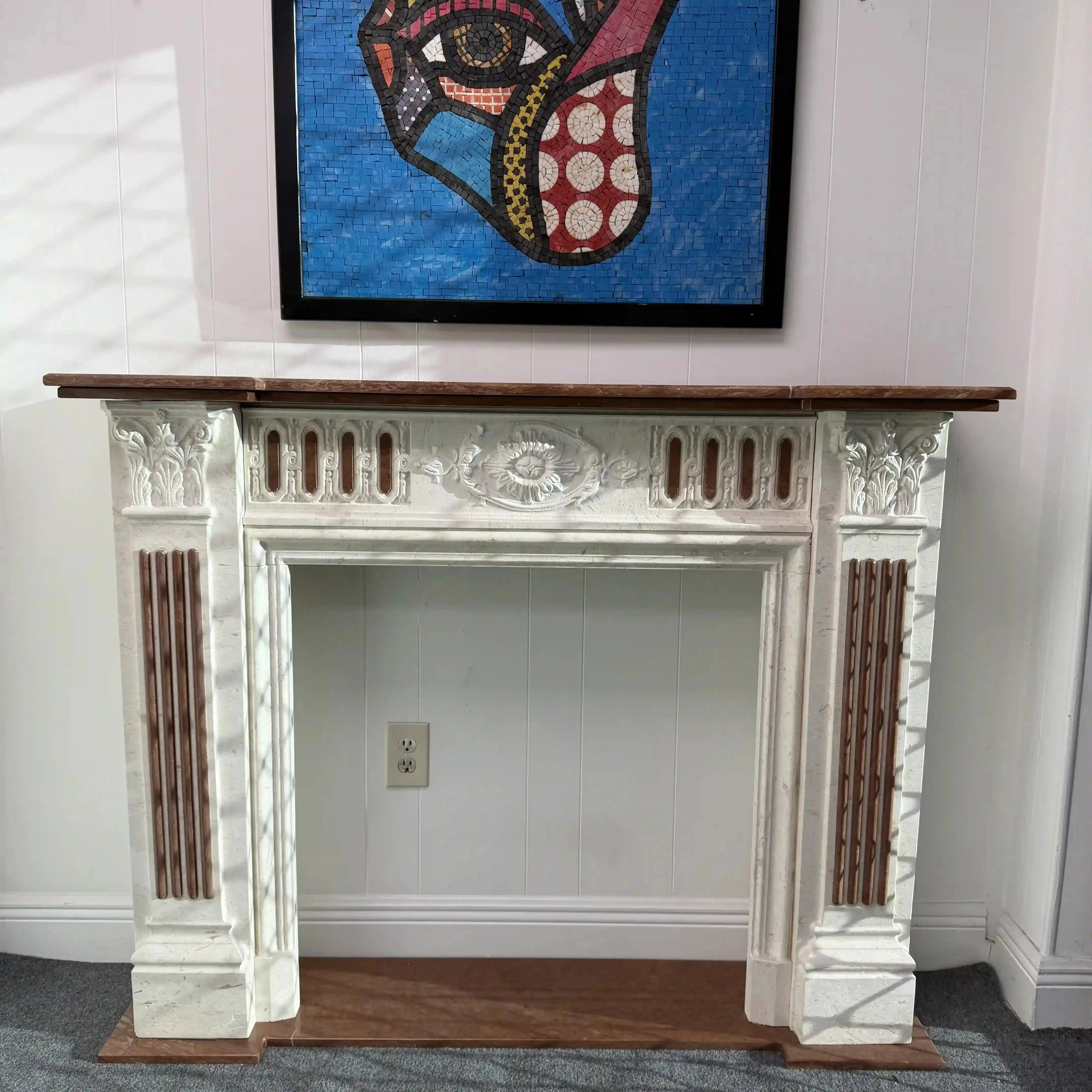 Decorative fireplace with a colorful abstract painting above it on a white wall.