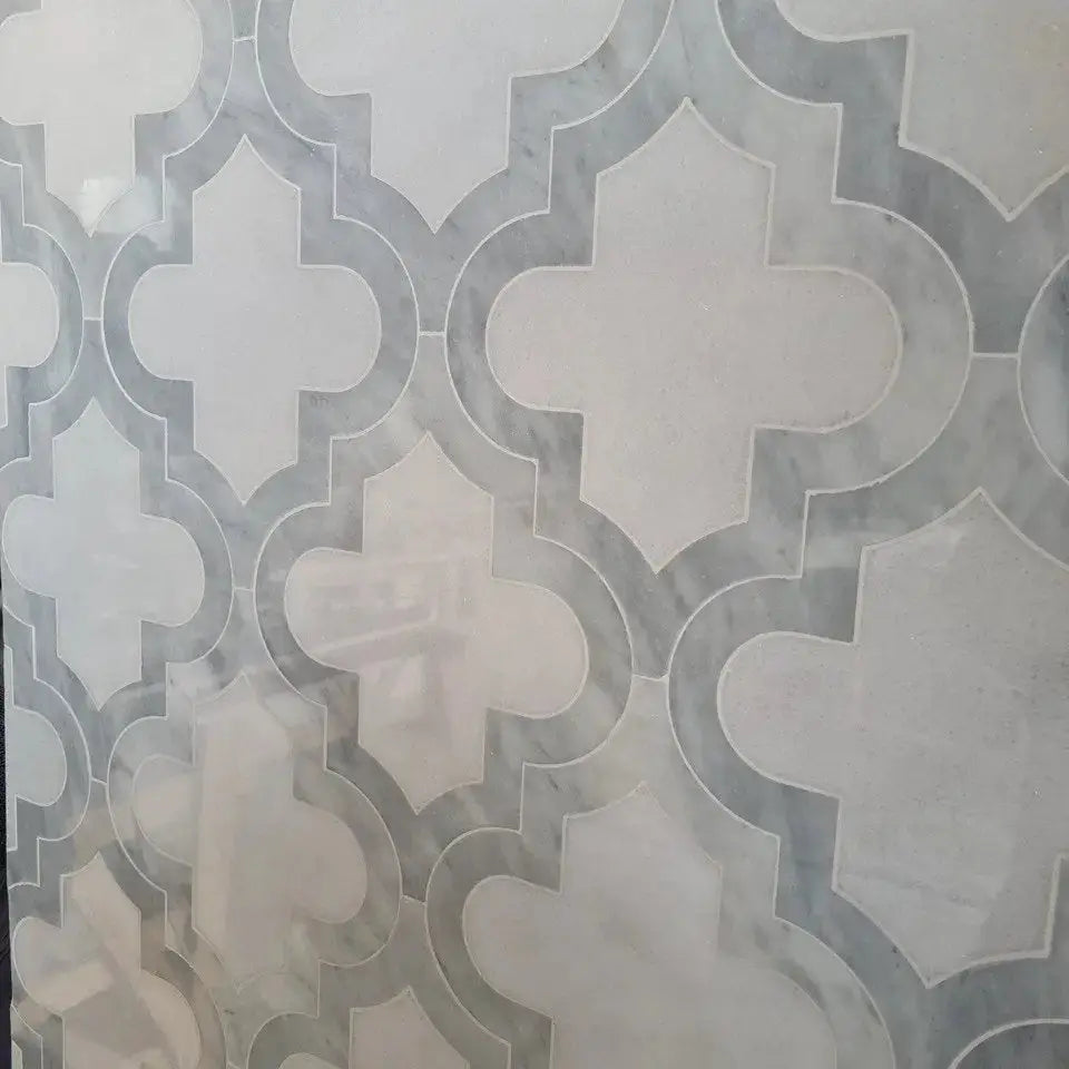 Ares marble mosaic tile featuring a repeating quatrefoil geometric pattern in soft grey and white natural stone tones.