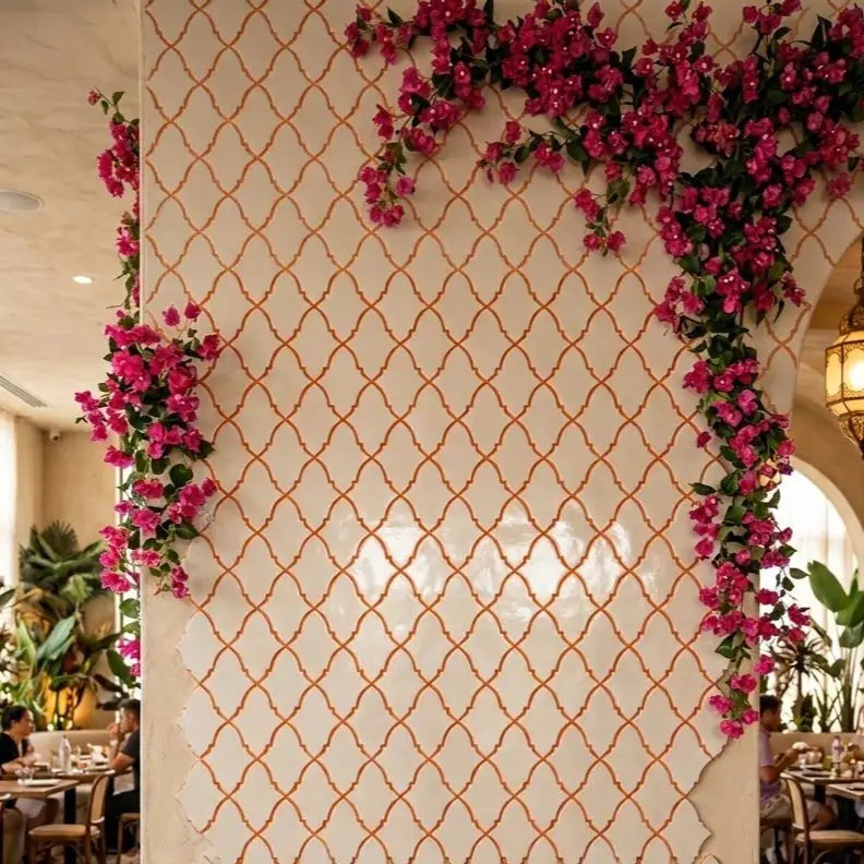 natural stone mosaic tile featured as an expansive wall cladding adorned with cascading vibrant pink bougainvillea flowers, highlighting its clean white marble surface and delicate decorative lines in an ambient interior setting.